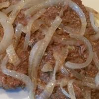 Bistec Encebollado · Grilled steak with onions.