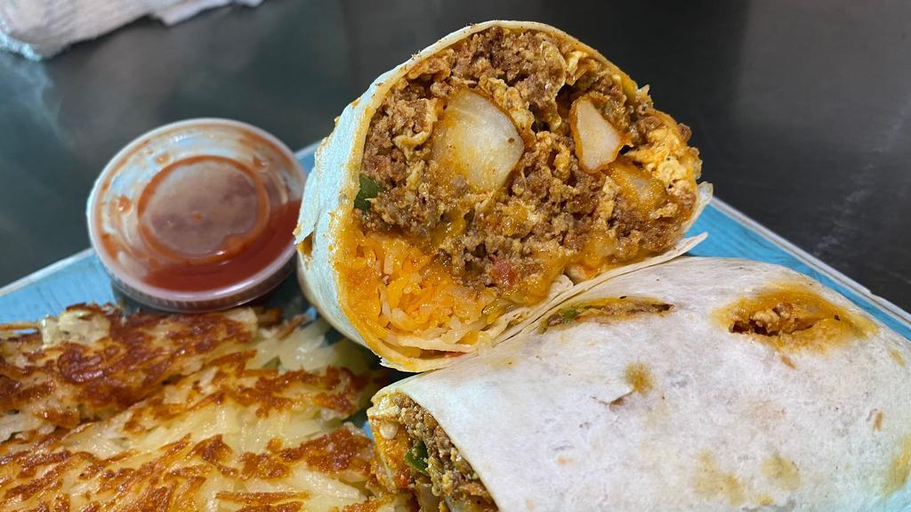 Breakfast Burrito · Breakfast burrito made with bell pepper onions tomatoes three eggs cheese potatoes and your choice of meat chorizo sausage or bacon serve with hash brown