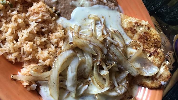 Chicken Yolanda · Grilled chicken breast topped with sted onions and queso. Served with rice, beans, and tortillas.