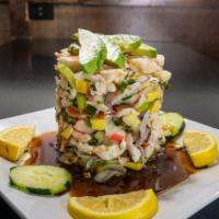 Torre De Marisco · A seafood mix stack layered with fresh cucumbers, onions and avocado slices served with savo...
