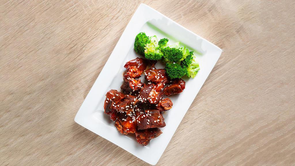 Short Ribs 秘制小排骨 · Marinated pork ribs with house special sauce, served with broccoli, sesame, and cilantro.