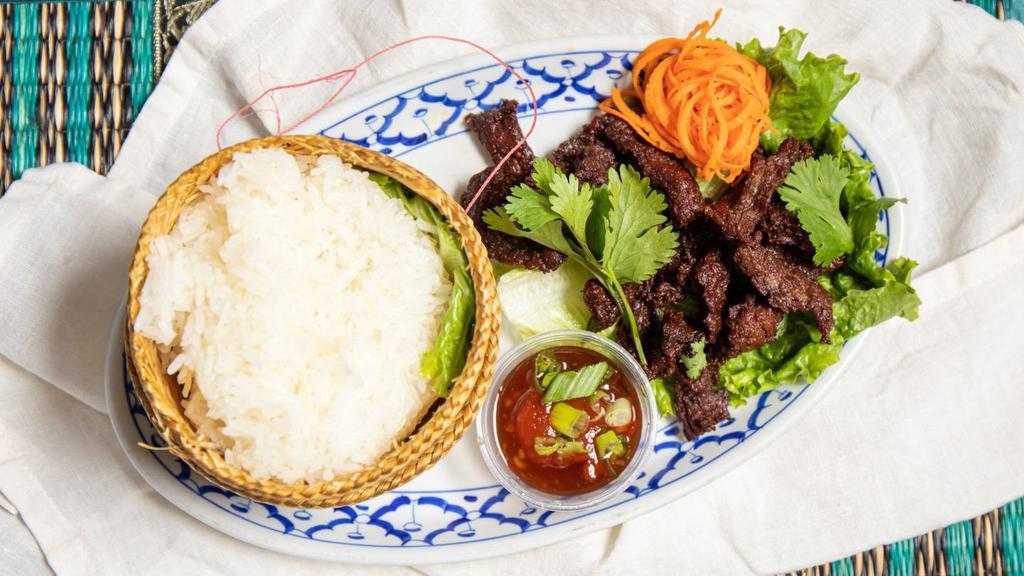Beef Jerky And Sticky Rice · Beef strips marinated in Thai spices and herbs, grilled and lightly fried, served with hot chili sauce and sticky rice.