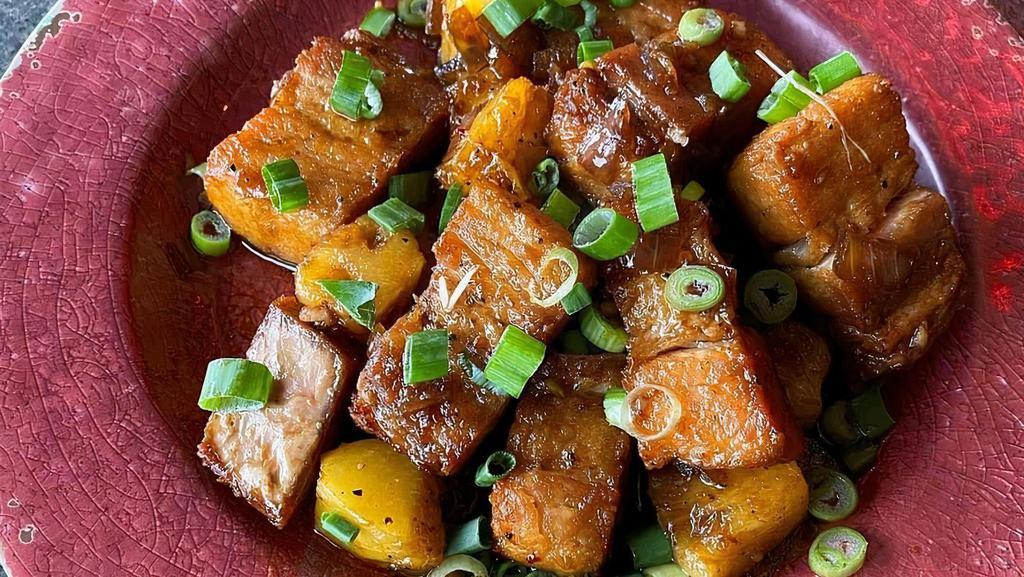 Maui Bacon · Fried pork belly, tossed with pineapple in a soy-honey sauce.  Garnished with scallions.