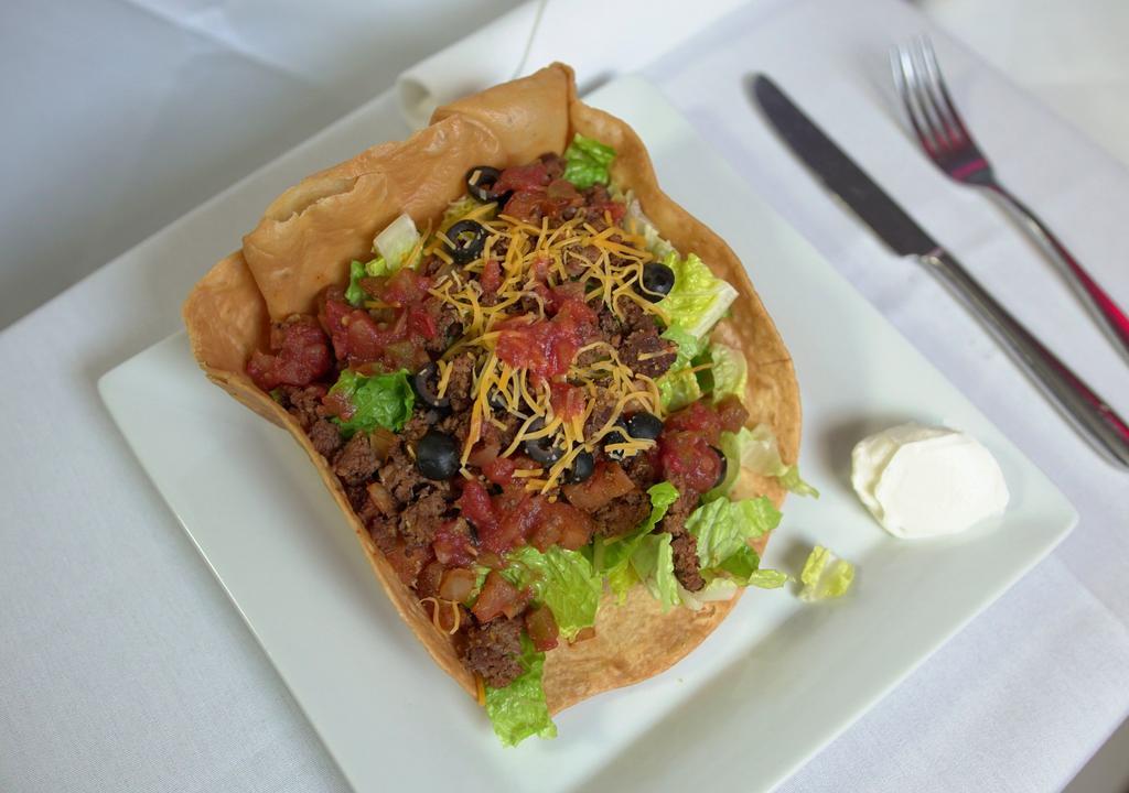 Taco Salad · Chicken or Beef, Black olives, tomatoes, onions, sour cream and salsa in our homemade taco shell.