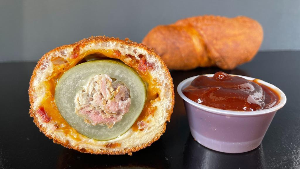 Porky Dill Dough · Cored Dill Pickle stuffed with Hickory Smoked Pork, rolled in a Cheddar and Bacon Infused Dough then fried crisp.