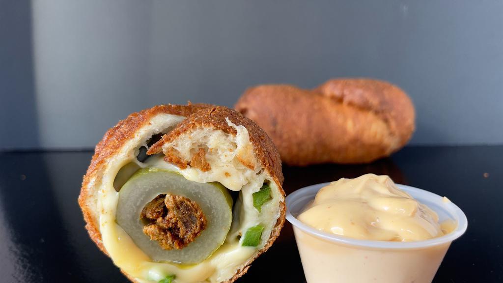 Taco Dill Dough · Cored Dill pickle stuffed with spicy Chorizo and creamy Chihuahua cheese. Rolled in a Jalapeño dough fried crisp.