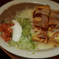 Steak Chimichanga · A steak fried chimichanga topped with salsa and cheese sauce, garnished with lettuce, tomato...