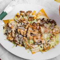 Nachos Al Carbon · Grilled chicken, steak and shrimp atop a bed of tortilla chips covered with shredded cheese,...