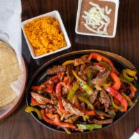Fajitas De Steak Dinner · Skirt steak with grilled slices of onions, green and red peppers served with Mexican rice, b...