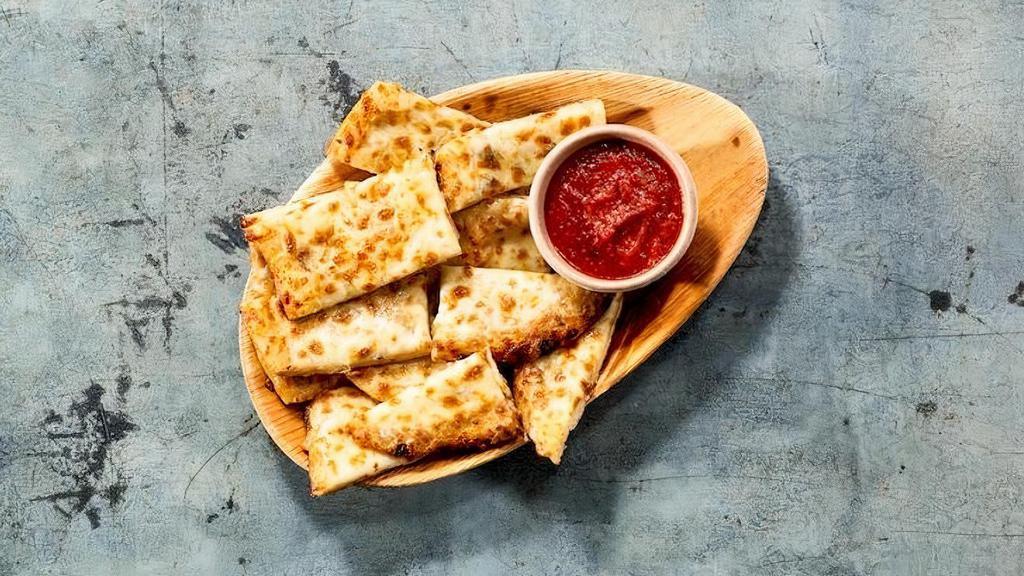 Cheesy Garlic Naan Bites · Signature Naan smothered with garlic & cheese served with Red-Hot sauce