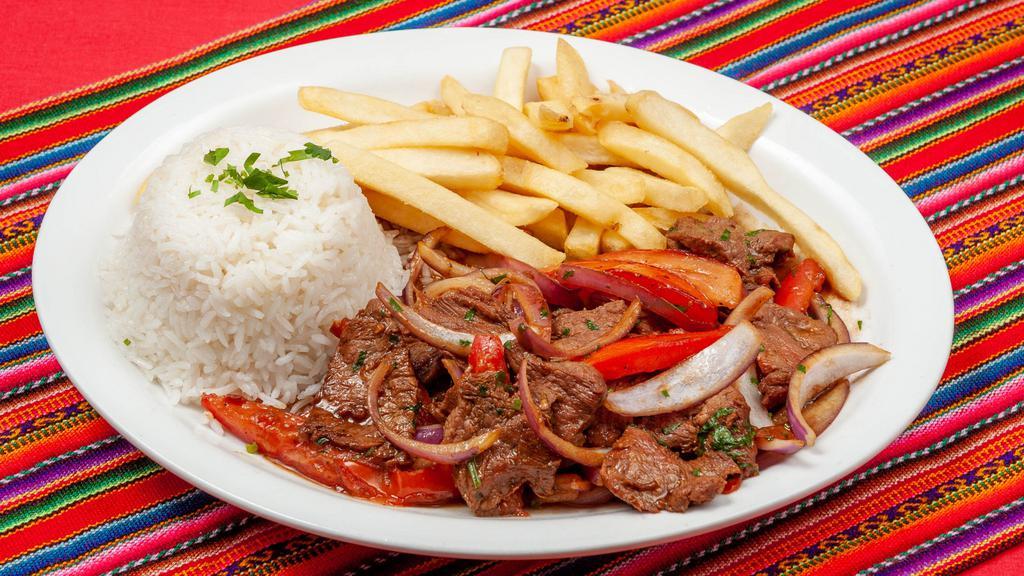 Lomo Saltado · Beef stir-fried with onions, garlic, tomatoes, cilantro, white  wine and soy sauce. Served with rice and fries.