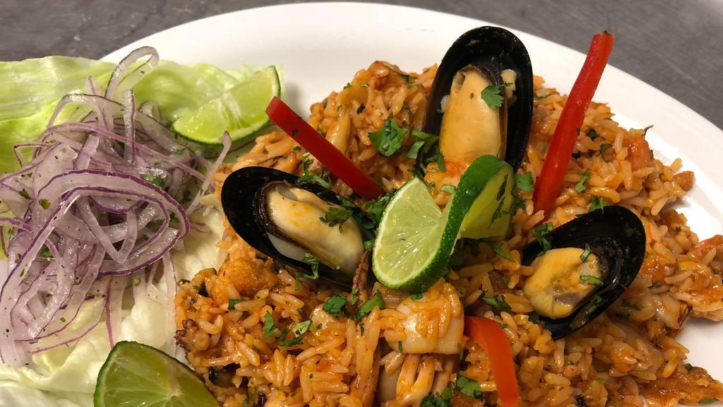 Arroz Con Mariscos · Rice cooked in aji amarilla and panca sauce with shrimp, mussels, calamari, squid, lime, cilantro.