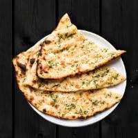 Garlic Naan · Soft and fluffy Indian flatbread infused with garlic flavor.