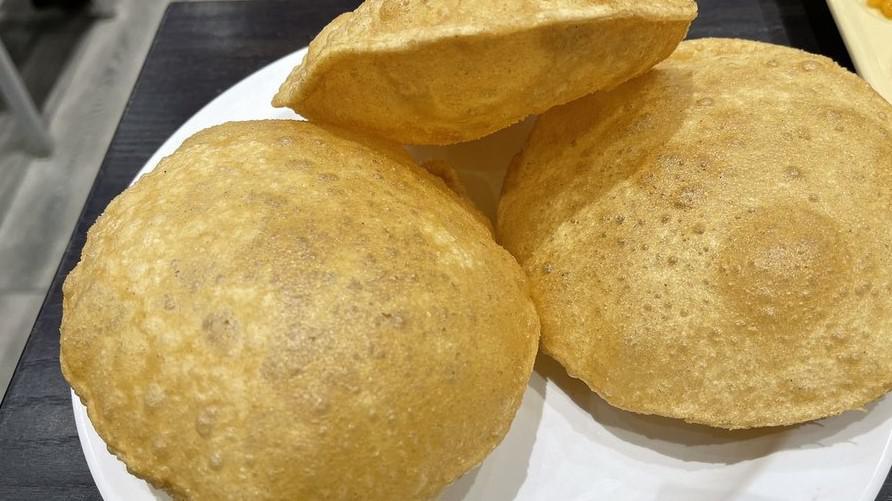 Chole Puri · Masala chickpeas with 3 puri (Fried Bread) served with halwa, pickle, sweet yogurt, and onions. Puri is made with whole-wheat flour and oil.