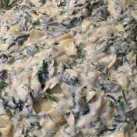 Spinach Artichoke Dip · Fresh spinach in a creamy artichoke dip served with fresh cut tortilla chips and toasted pit...