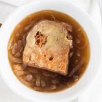 French Onion Soup · Caramelized onion soup topped with a large French bread crouton and melted swiss cheese bowl.