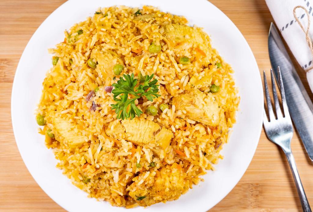 Chicken Biryani · A Mughlai dish prepared with chicken and green peas with saffron flavorful rice, garnished with raisins and cashews.