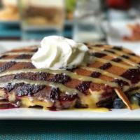 Lemonberry Pancakes · Blueberry pancakes topped with lemon curd, blueberry syrup and whipped cream