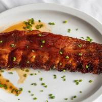 Baby Back Ribs · Fall of the bone pork ribs baked in a tangy BBQ sauce.