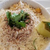 Esquite (Mexican Street Corn) · Warm buttery corn topped with mayo mix, cotija cheese, and chili powder.