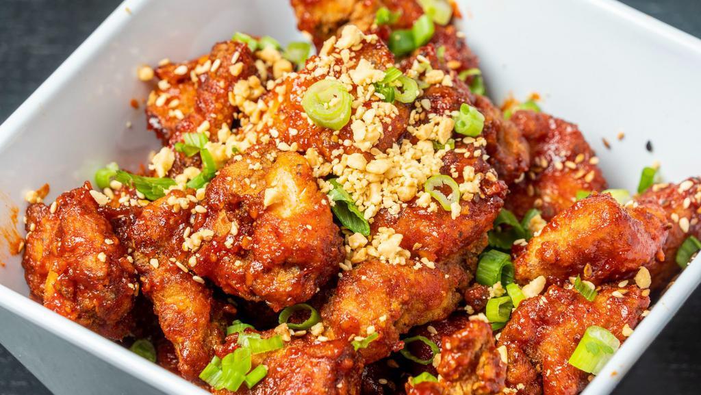 Korean Fried Chicken · Korean style Twice Fried Chicken wok tossed in our Spicy Korean Sauce, Garlic, Sesame Seeds, Peanuts, and Green Onions.  Finished in our Chili Oil.  A must have item!