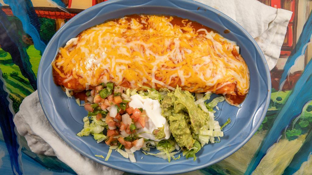 Ultimate Fajita Burrito · Larger tortilla stuffed with steak or chicken, rice and beans, sautéed bell peppers, onions, and tomatoes. Covered in ranchero sauce and garnished with lettuce, tomatoes, and sour cream.