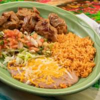 Carnitas Dinner · Tender shredded pork served with rice, beans, guacamole salad, and tortillas.