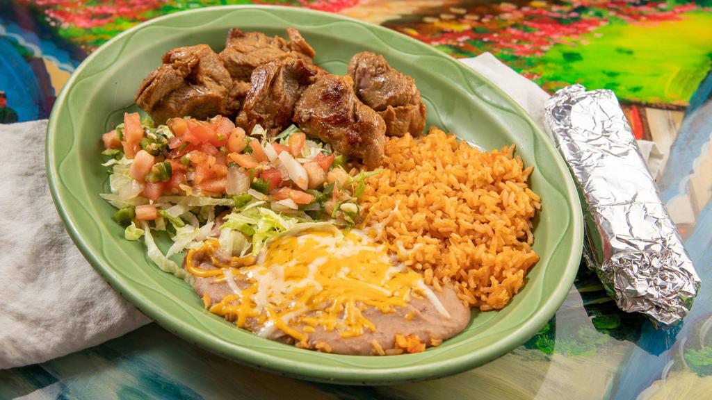 Carnitas Dinner · Tender shredded pork served with rice, beans, guacamole salad, and tortillas.