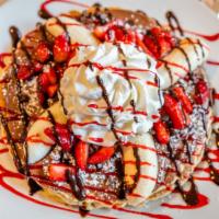Nutella® Pancakes · 4 cakes topped with fresh strawberries, bananas, chocolate chips and whipped cream. Served w...