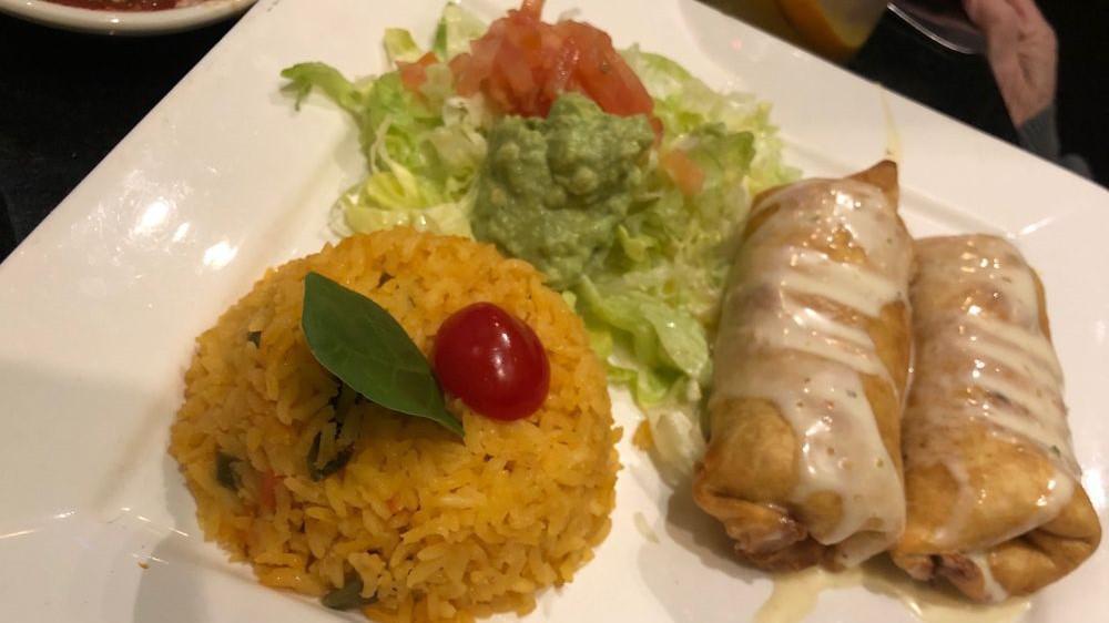 Chimichangas · Two flour tortillas rolled up and stuffed with shredded beef, pork, lobster, shrimp or chicken, then covered with cheese sauce, served with rice or beans and guacamole salad.