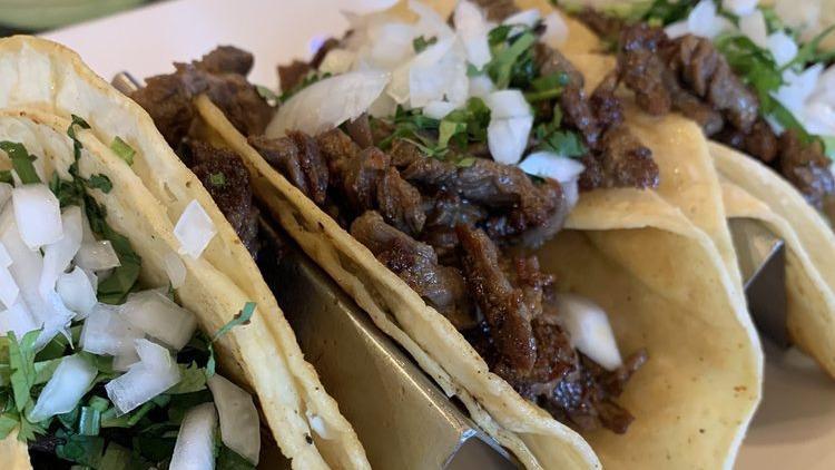 Street Tacos · Three soft corn tortillas stuffed with your choice of meat, topped with fresh cilantro and onions. Served with a side of tomatillo sauce.