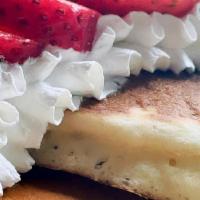 Fresh Strawberry Pancakes · Three pancakes dusted with powdered sugar and topped with fresh strawberries, whipped cream ...