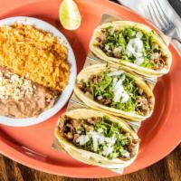 Tacos De Pastor · Three tacos filled with marinated pork chunks topped with pineapple -cilantro and onion Serv...