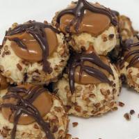 Turtle Thumbprint Cookie · Shortbread cookie with caramel center, pecans on the sides and chocolate drizzled on top