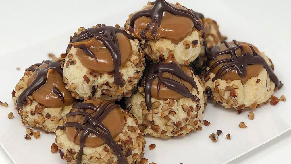 Turtle Thumbprint Cookie · Shortbread cookie with caramel center, pecans on the sides and chocolate drizzled on top