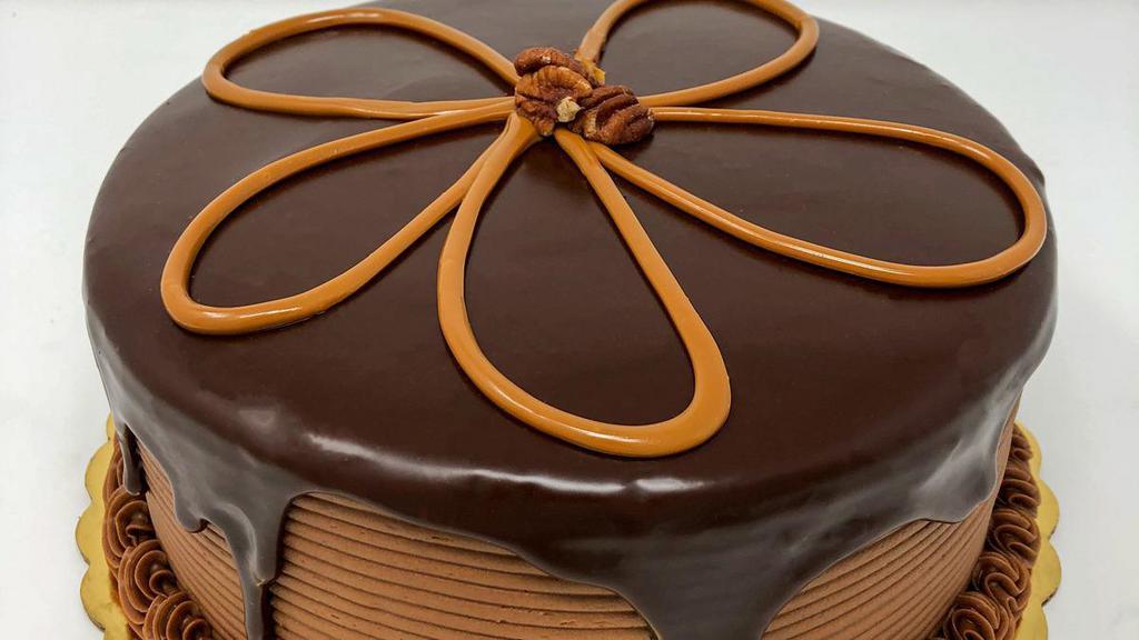 Turtle Dessert Cake · Chocolate cake with chocolate and caramel filling iced in chocolate buttercream topped with a ganache waterfall and caramel and pecans!