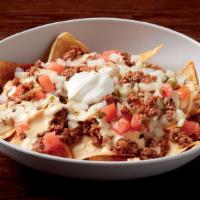 Our Burger Nachos · Fresh ground beef, cheese sauce, tomatoes, onions, pickles, Paul's signature wahl sauce, sou...