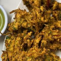 Golden Veggie Fritter · Vegan. A medley of onions hand-made fresh to order then dipped in chickpea and rice flour ba...