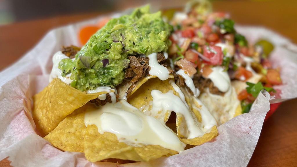 Birria Nachos · Chips coved in our homemade cheese dip, Birria beef, pico de gallo, sour cream, jalapeños and guacamole(add on) to make the perfect appetizer!