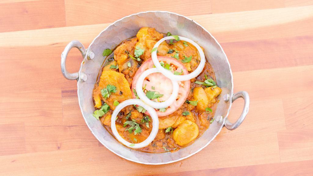 Aloo Tarkari · Vegan. Fresh potatoes flash fried in a wok with sliced tomato, cilantro, green chili and onion masala sauce.