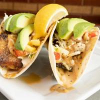 Brett'S Fish Tacos · Blackened tilapia in two flour tortillas, fresh avocado, shredded cabbage, Monterey jack che...