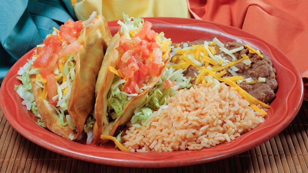 Taco Plate · Two tacos (beef or chicken) with a side of beans and rice. All Tacos are topped with shredded lettuce, cheese and diced tomatoes.
