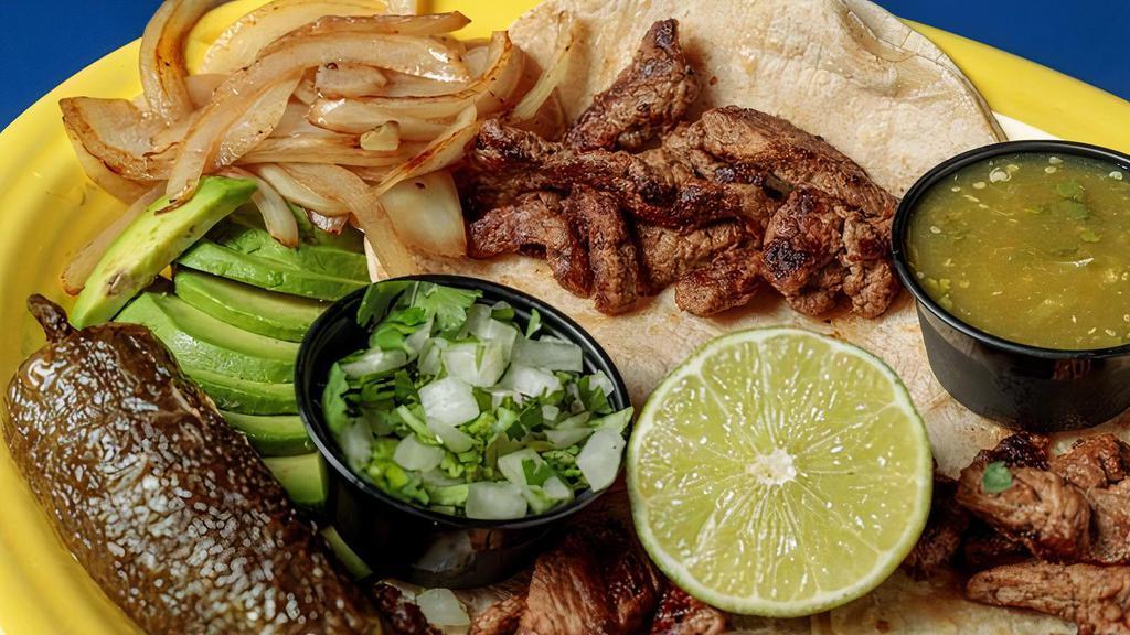  Steak Tacos · Three soft corn tortillas filled with our marinated steak, garnished with grilled onions, fresh avocado slices, cilantro onion mix, a lime, and a fried whole jalapeño. Served with rice and beans.
