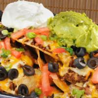 Nacho El Kitchen Sinko · Beef or chicken over freshly made corn chips with cheddar and jack cheese, beans, tomatoes, ...