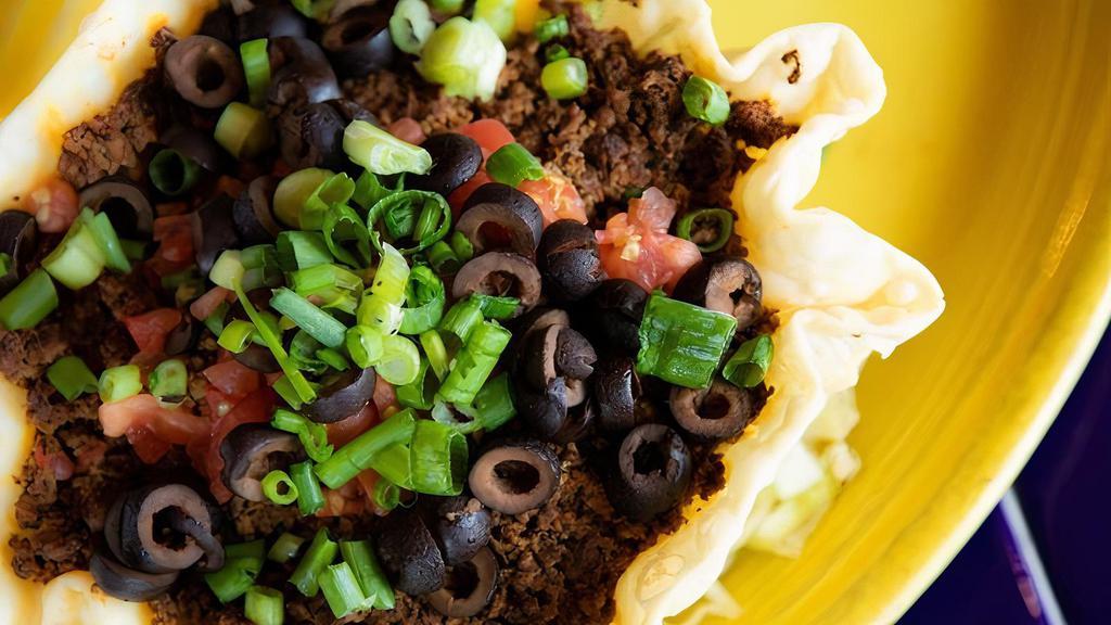 Taco Salad · Shredded lettuce, tomato, black olives, cheese, and scallions topped with your choice of beef or chicken all in a tortilla bowl, served with ranch dressing and ranchero sauce.