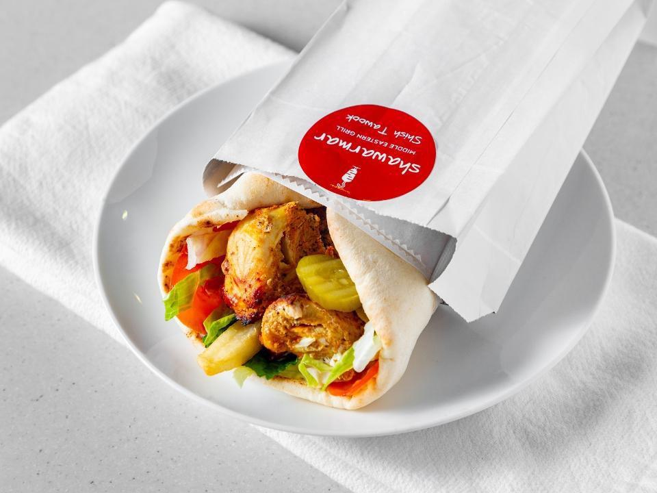 Shish Tawook Wrap · A boneless breast of chicken, marinated in our special marinade and a blend of spices, grilled to perfection for a tender and juicy authentic Mediterranean taste, wrapped in thin pita bread with a hint of creamy garlic sauce, mint leaves, pickles, and fries.