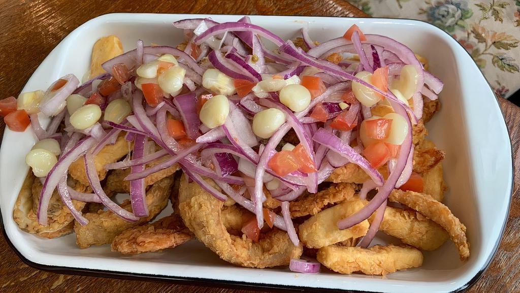 Fried Seafood And Fish (Jalea) · Great to share! Crispy pieces of fish, shrimp with mussel’s and calamari, with an unmatched taste accompanied with golden yucca, tartar sauce and topped with Creole Sauce (onion, tomatoes, lemon, cilantro, and olive oil)