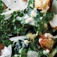 Kale Caesar Salad · Baby kale, arugula, romaine, shaved parmesan, cherry tomatoes, Caesar dressing and croutons.