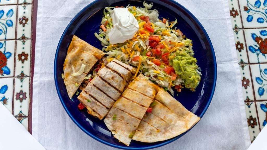 Quesadillas De Fajitas · Filled with your choice of beef, chicken or combination fajitas. Served with lettuce, guacamole, tomato, and sour cream.