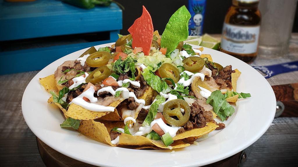 Nachos Mexicanos · Crisp tortilla chips topped with melted Chihuahua cheese, beans, jalapeño peppers, sour cream, guacamole, lettuce, pico de gallo and choice of meat.